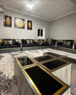 Opulent black and gold Arabic seating by Diwanzane, with plush cushions and an intricate rug design that elevates the room’s luxurious feel.