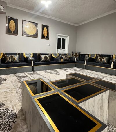 Opulent black and gold Arabic seating by Diwanzane, with plush cushions and an intricate rug design that elevates the room’s luxurious feel.