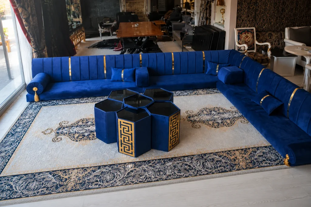Custom blue velvet diwan sofa in Michigan displayed with gold accents and modular hexagonal tables